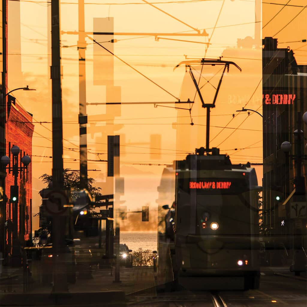 Photo image of a historic Seattle streetcar gliding past buildings, capturing movement and nostalgia in an urban setting.
